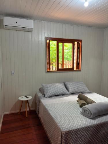 a bedroom with two beds and a window at Casa da Serra borrussia in Osório