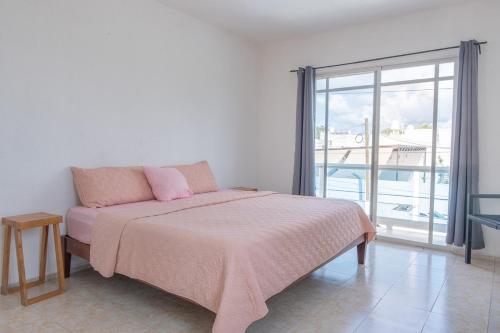 a bedroom with a bed and a large window at Casa completa con alberca en Chetumal in Chetumal