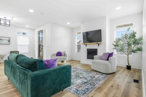 a living room with a green couch and a tv at Near Indy Attractions • Deck • Patio • Fenced Yard in Indianapolis
