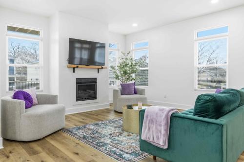 a living room with two chairs and a tv at Near Indy Attractions • Deck • Patio • Fenced Yard in Indianapolis