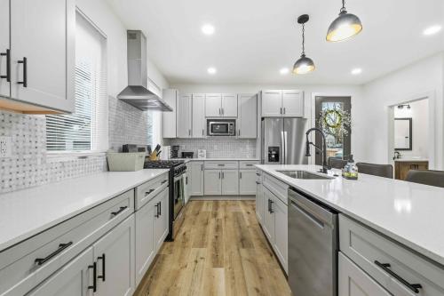 a kitchen with white cabinets and a large kitchen island at Near Indy Attractions • Deck • Patio • Fenced Yard in Indianapolis