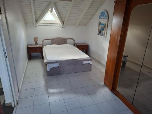 a bedroom with a bed and a table and a window at Spacious 2 beds flat in Grande-Terre center in Morne-à-lʼEau