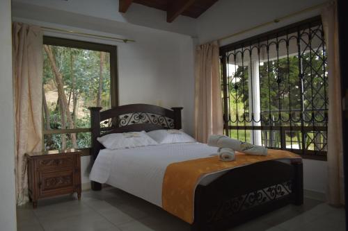 a bedroom with a bed and a large window at Cabaña Campestre Bellavista in Paipa