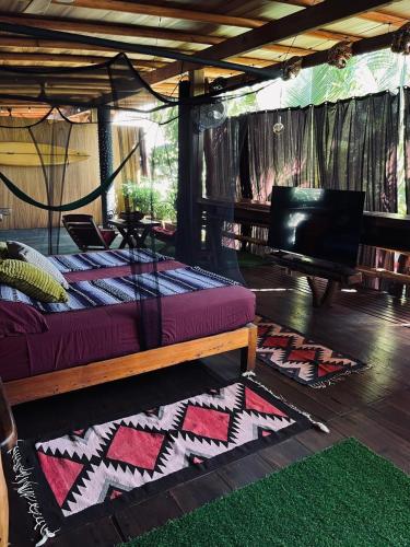 a room with a bed and a piano and rug at Casa Frutas y Verduras in Puerto Escondido