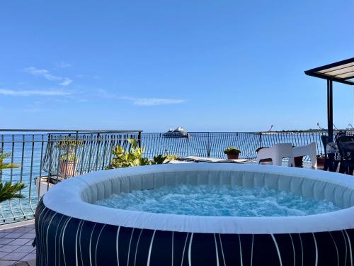 a hot tub on a patio overlooking the ocean at Miriam Sea Front Apartment Jacuzzi in Giardini Naxos