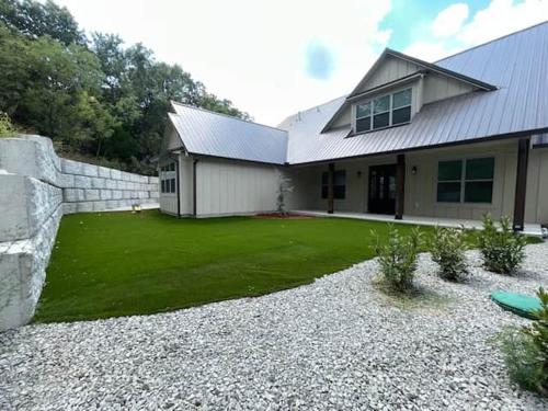 a house with a yard with a stone wall at Lakeside Oasis in Longtown