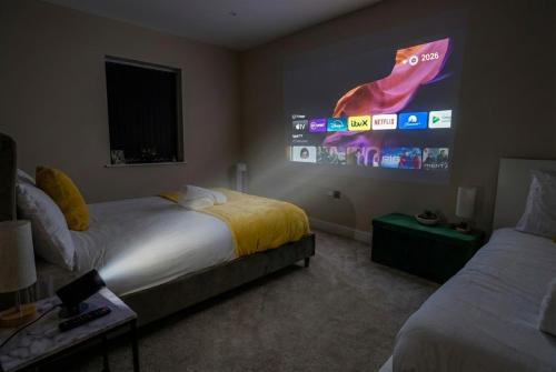 a bedroom with two beds and a large screen at City Spacious Apartment in Central Station