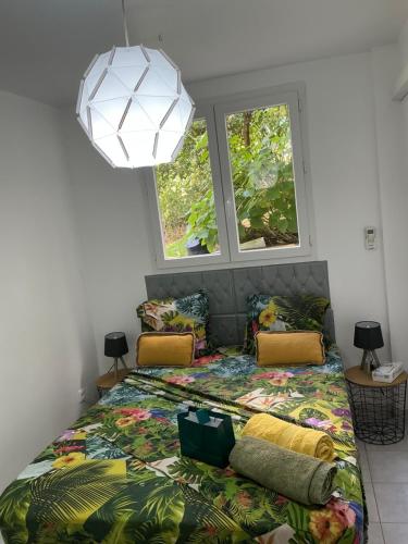 a bedroom with a bed and two windows at Résidence Flores De Maria in Le Marin