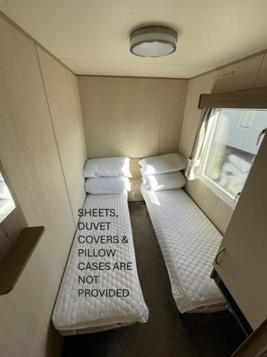 a small room with two beds in a trailer at Golden Sands Mablethorpe 8 Birth Caravan in Mablethorpe