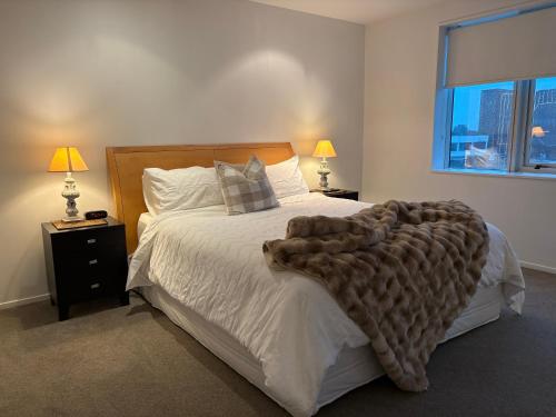 a bedroom with a large bed with a blanket on it at Apartment 303 Tauranga in Tauranga