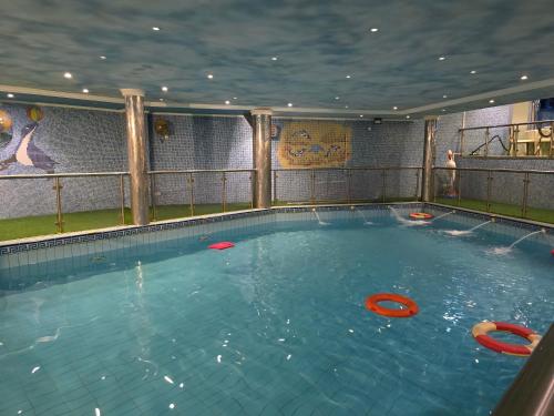 a large swimming pool with red frisbees in it at Taj Celine Hotel in Jeddah