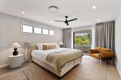 a bedroom with a bed and a couch and a window at Beachfront Wellness Retreat in Kingscliff