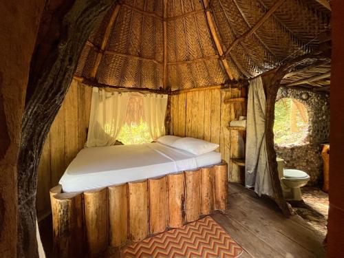 a bed in a tent with a toilet in it at Hostal Paraíso Tayrona Kogui in Santa Marta