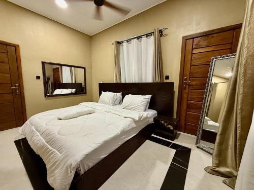 a bedroom with a large bed and a mirror at Accra Luxury Apartments At The Sanga Estates in Accra