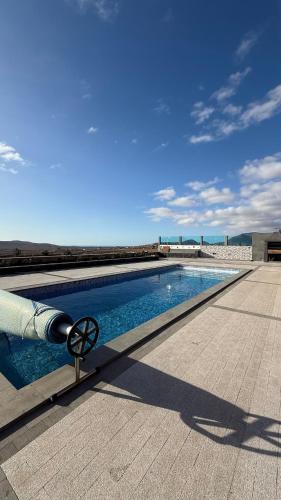 a swimming pool on the roof of a building at Yellow Room - Sunlite Double Private Room in Villa Barbuja in Tefía