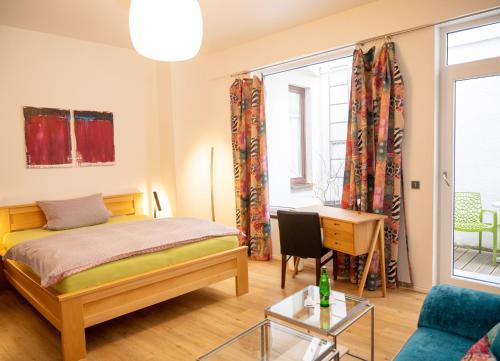 a bedroom with a bed and a desk and a window at Boutique Hotel Frieden in Weiden