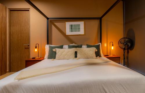 a bedroom with a large white bed with two lamps at Capitalia Downtown Del Valle in Mexico City