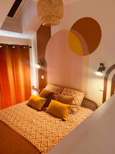 a bedroom with a bed with yellow pillows on it at Duplex house with small terrace in Bayeux