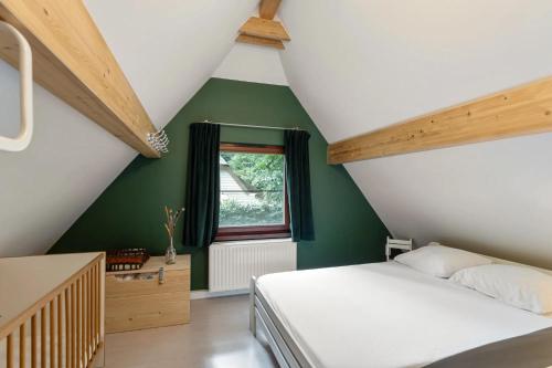 a bedroom with green walls and a bed and a window at Riet&Rust in Lanaken