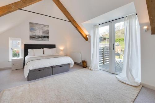 a white bedroom with a bed and a large window at 3 Bed in Croyde oc-croyco in Croyde