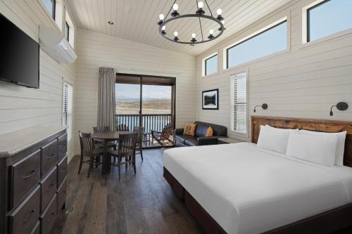 a bedroom with a bed and a table with chairs at Sun Outdoors Rocky Mountains in Granby