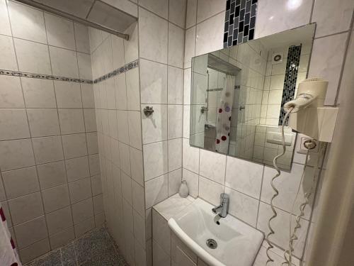 a white bathroom with a sink and a mirror at Lessinghof in Braunschweig