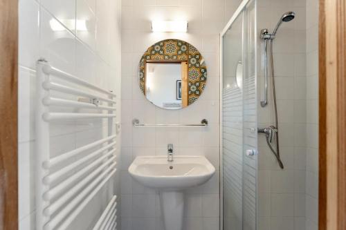 a white bathroom with a sink and a mirror at Riet&Rust in Lanaken