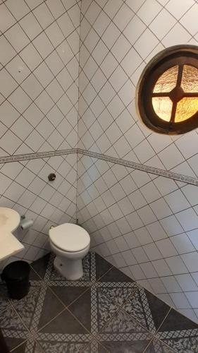 a bathroom with a toilet and a window at Sobrado em Coroados, Guaratuba PR in Guaratuba