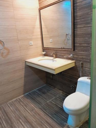 a bathroom with a sink and a toilet and a mirror at Urban Pearl Apartment in Rawalpindi