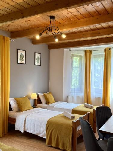 a bedroom with two beds and a table and chairs at Willa Maya in Karpacz