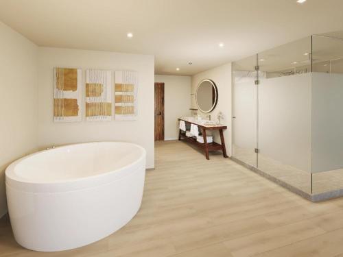 a white bathroom with a tub and a shower at Hyatt Vivid Grand Island Cancun-All Inclusive Adults Only in Cancún