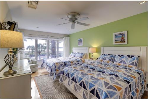 a bedroom with two beds and a ceiling fan at Beachside Tennis 1869 in Hilton Head Island