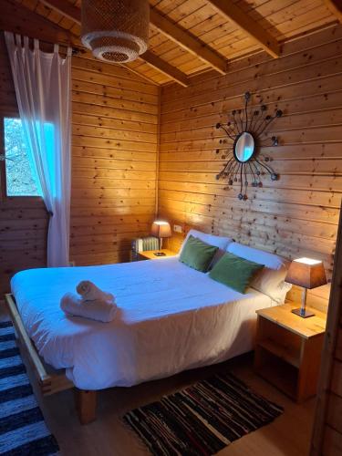a bedroom with a large bed with a wooden wall at La Cabaña Rural in Paúl