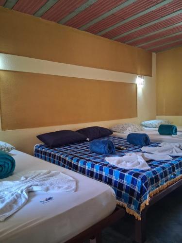 two beds in a room with clothes on them at Pousada Nosso Recanto Camocim in Camocim