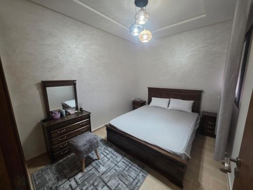 a bedroom with a bed and a dresser and a mirror at Massira Green Park Serenity in Kenitra