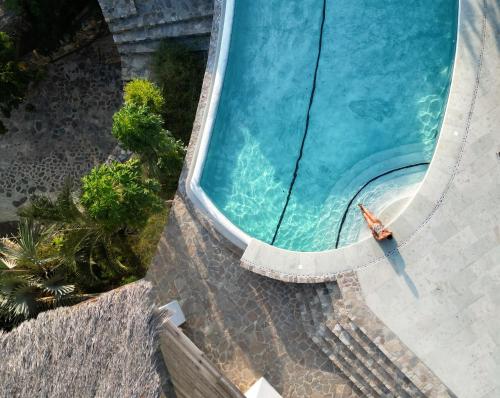 an overhead view of a swimming pool with a person in the water at Zazil Retreat in San Agustinillo