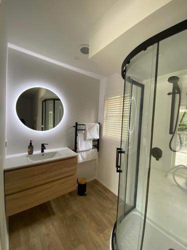 a bathroom with a sink and a mirror at Kauri Coast Bungalow in Karekare