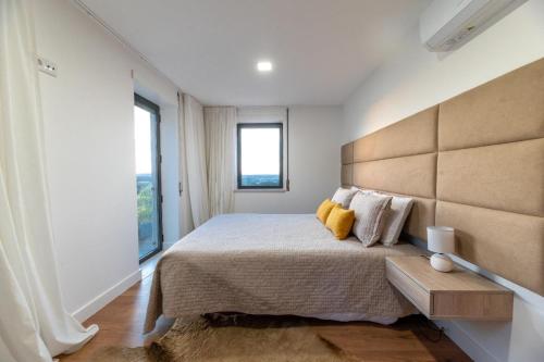 a bedroom with a large bed and two windows at Golden View in Vale de Tábuas