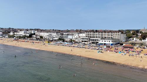 a beach with a bunch of people in the water at Sandringham Hotel - Seafront, Sandown, Isle of Wight - FREE CAR FERRY TICKET for 3 Nts, 1-2 Nts from 109 Pounds in Sandown