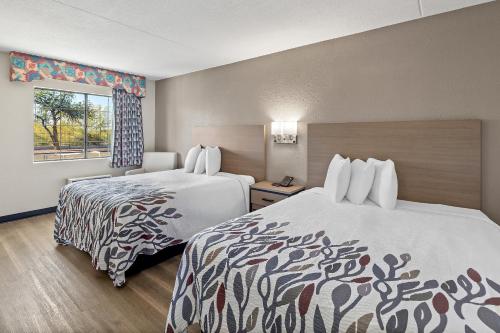 a hotel room with two beds and a window at Red Roof Inn Tucson - Vail in Tucson
