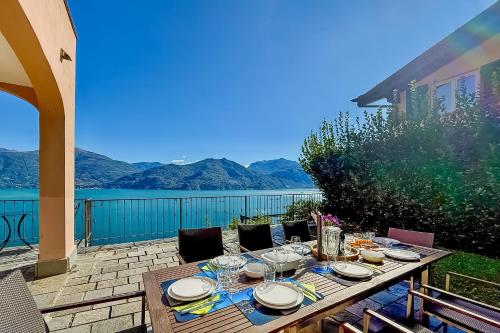 a wooden table with plates and wine glasses on a patio at Villa Panoramica in Menaggio