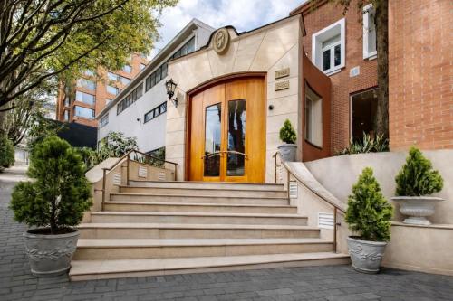 a house with stairs in front of a building at Hotel Portón de la Cabrera in Bogotá