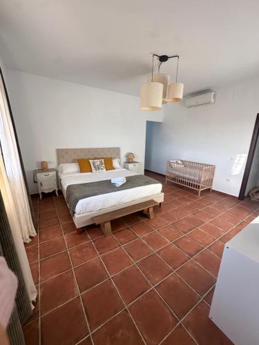 a bedroom with a bed and a tiled floor at Casa Alboroto in Puebla del Río