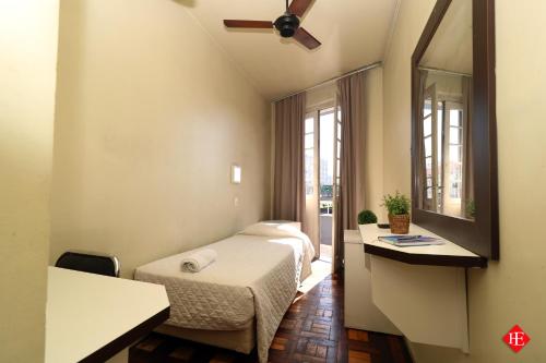 a hotel room with a bed and a mirror at Hotel Elevado in Porto Alegre