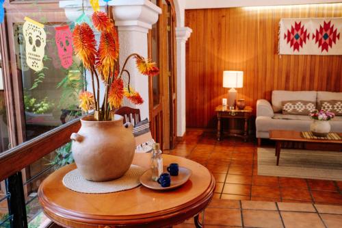 a living room with a vase with flowers on a table at Luminosa casa en barrio famoso in Oaxaca City