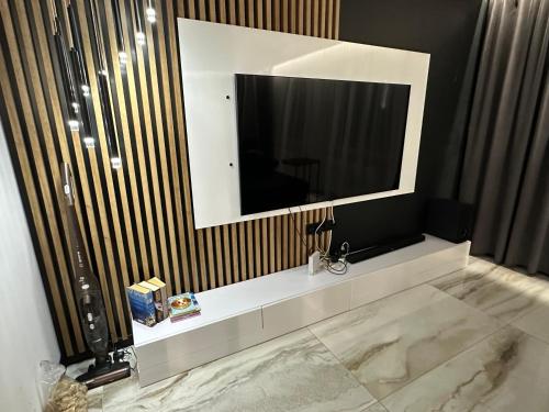 a bathroom with a large television on a wall at Slow Time in Morąg