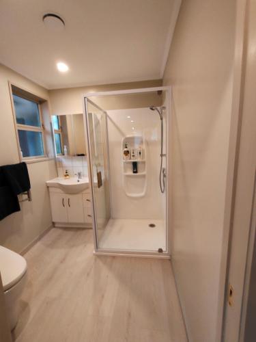 a small bathroom with a shower and a toilet at Orchards Retreat in Paraparaumu Beach