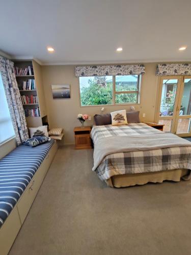 a bedroom with two beds and a book shelf at Orchards Retreat in Paraparaumu Beach
