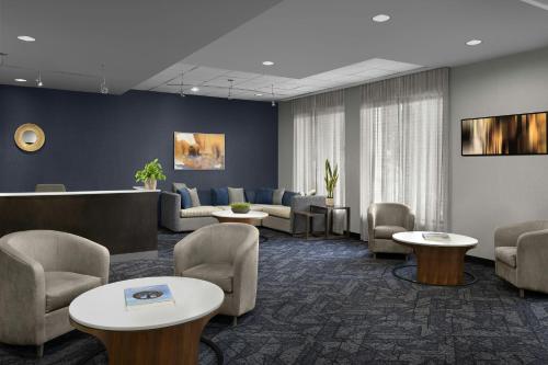 a waiting room with couches and chairs and tables at Courtyard Greensboro Airport in Greensboro