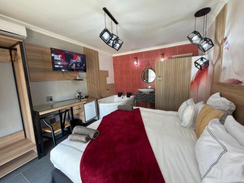 a hotel room with a large bed and a bathroom at Africa Prestige Boutique Hotel in Benoni